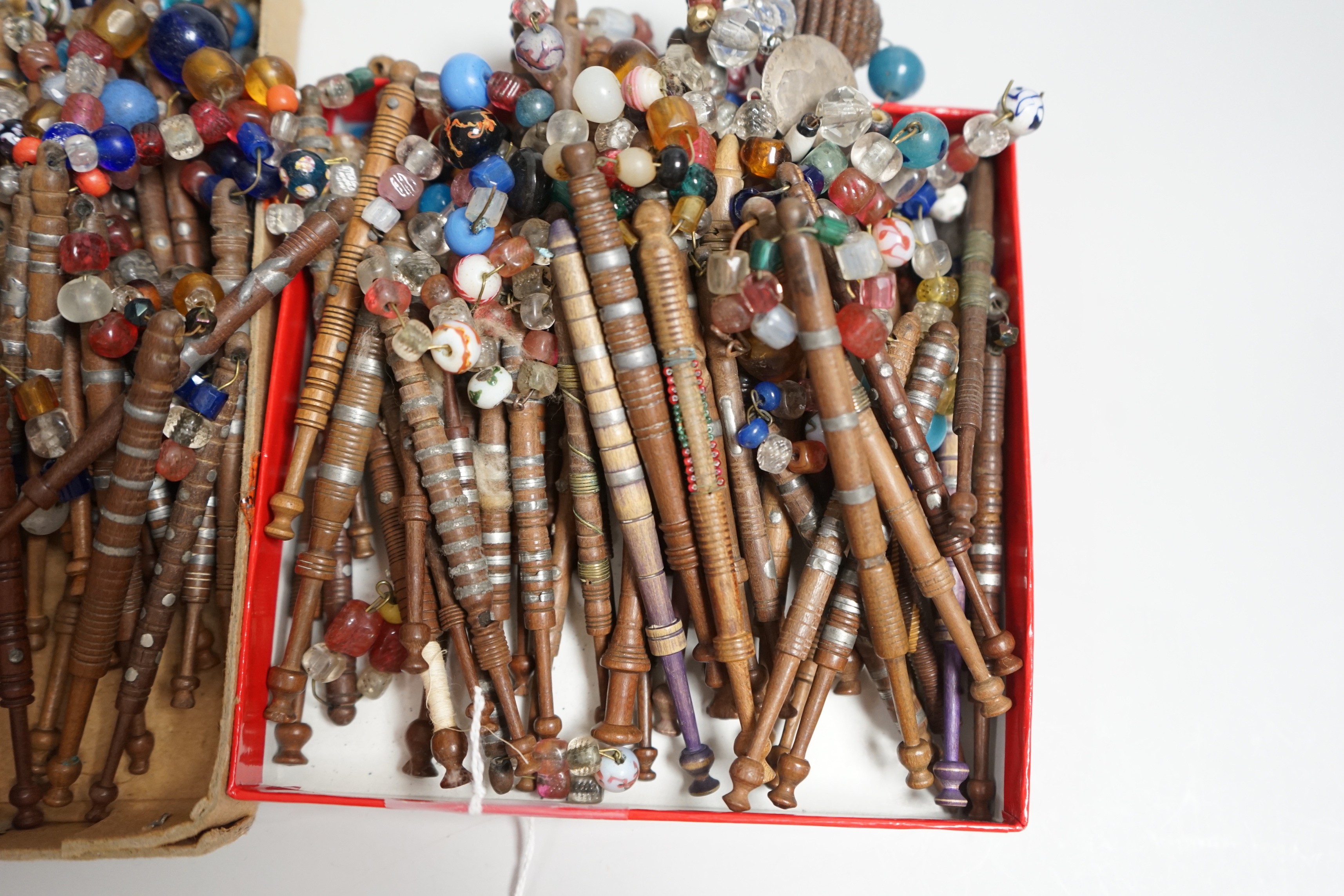 Eighty 19th century wood and metal decorated lace bobbins with coloured beaded tops